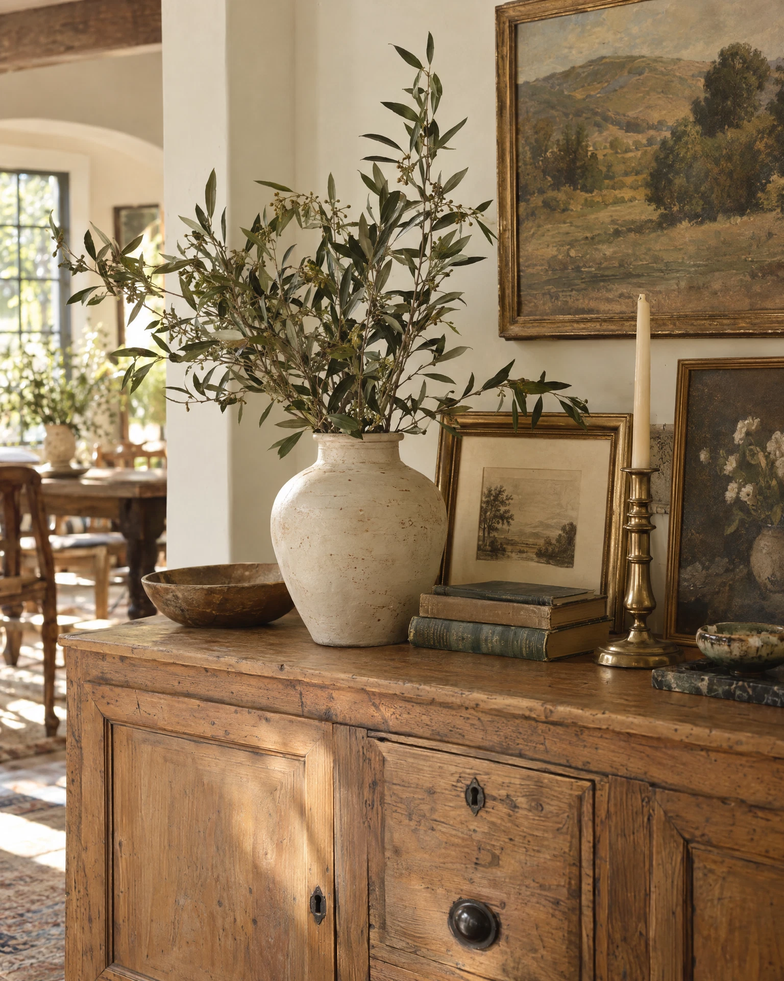 Illustrative vintage sideboard styled with a vase, books and framed art